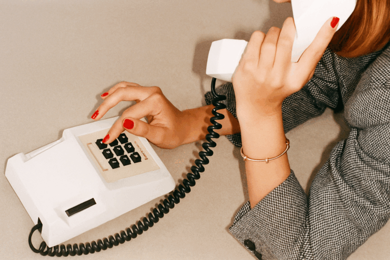 Atendimento da Kult representado por mulher ao telefone vintage, com estética editorial e toque retrô — símbolo de consultoria criativa e conexão próxima com clientes.